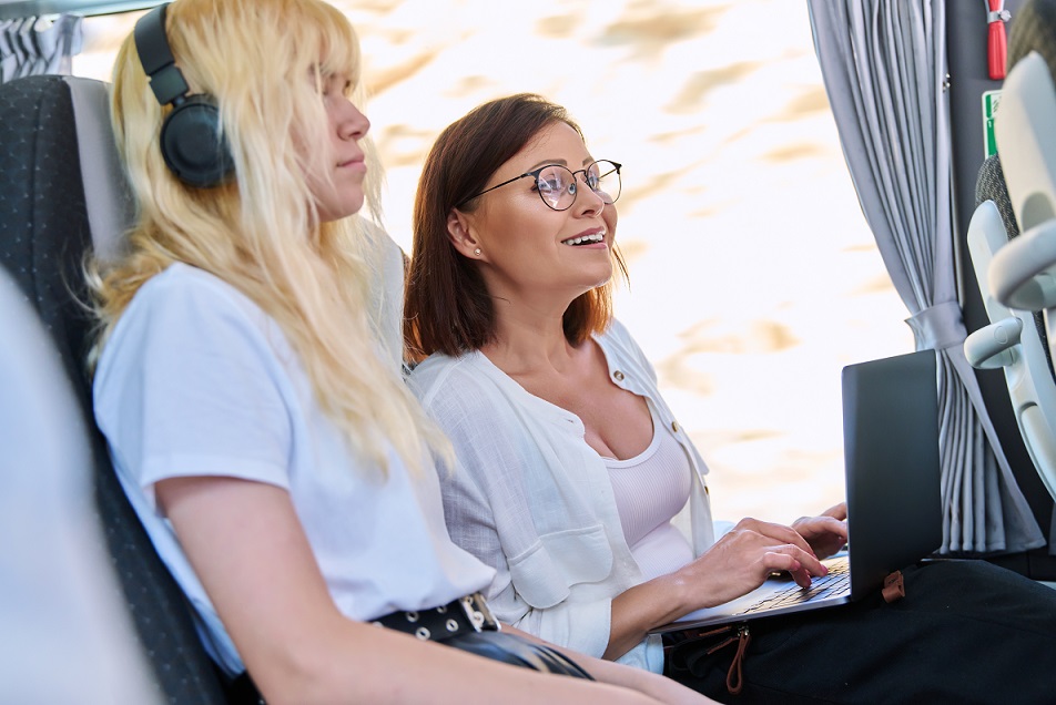 Middle-aged woman in a bus using a laptop.